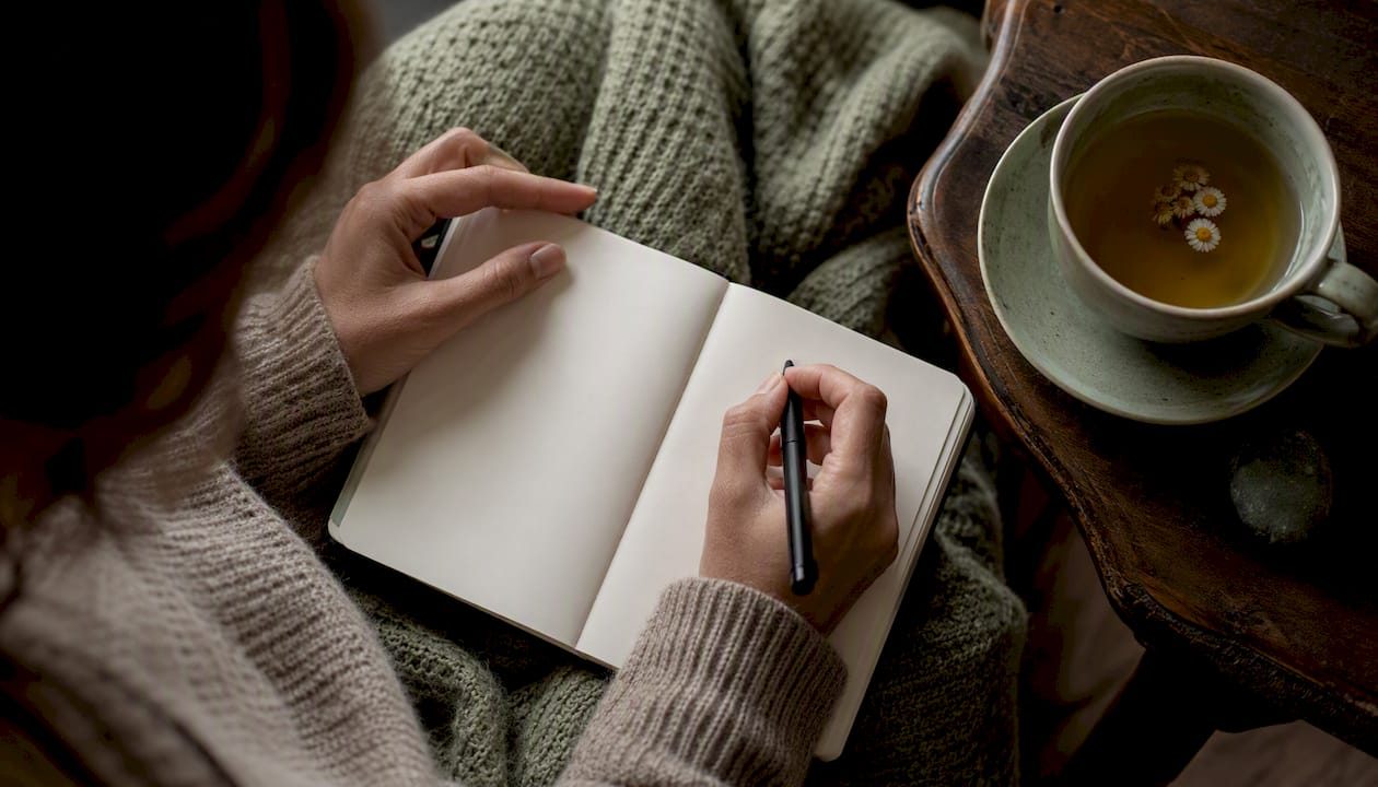 Hands journaling grief symptom log