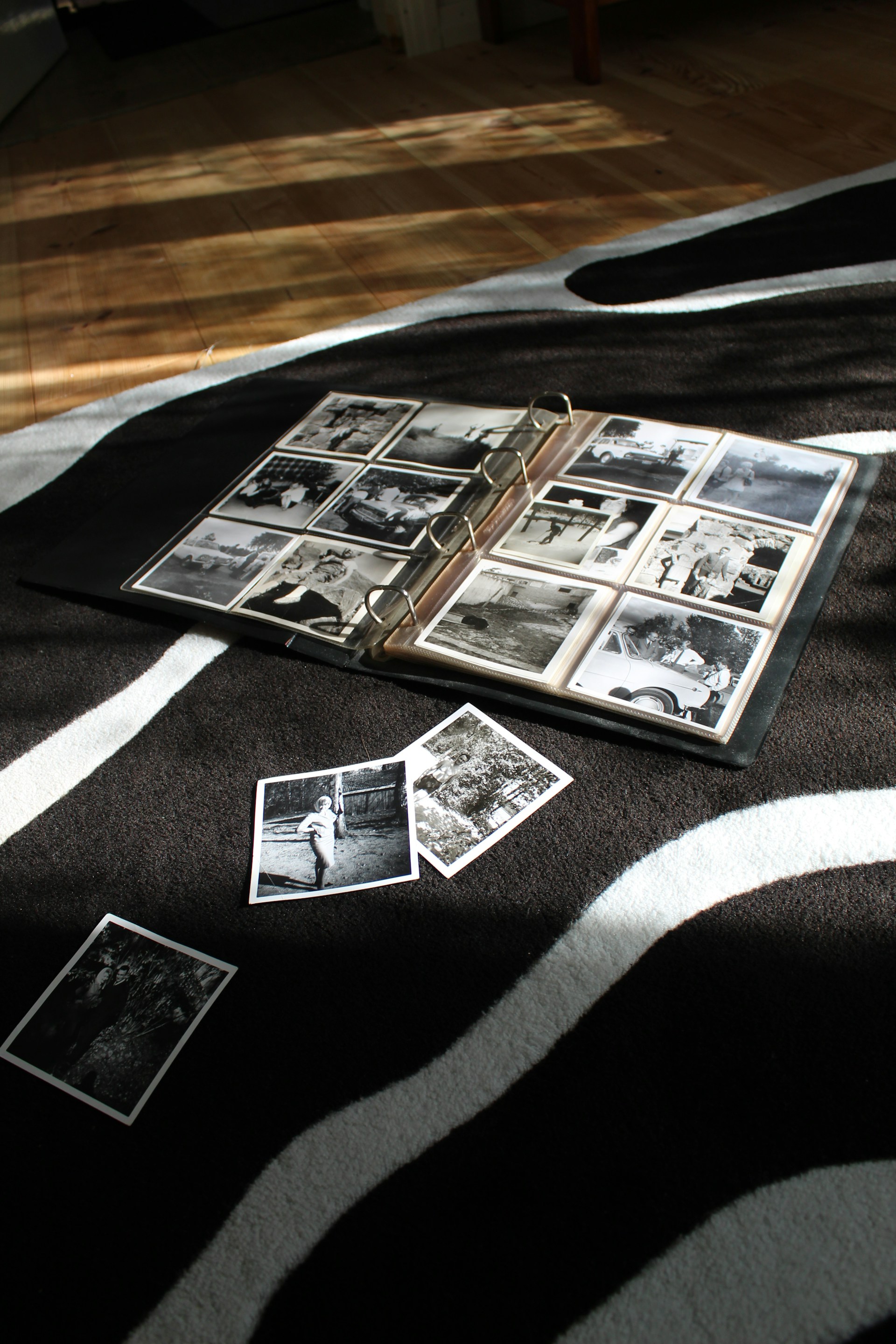 A person looking through old photographs spread across a table